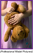 Young girl in pink dress clutching her teddy bear (Professional Model Pictured).